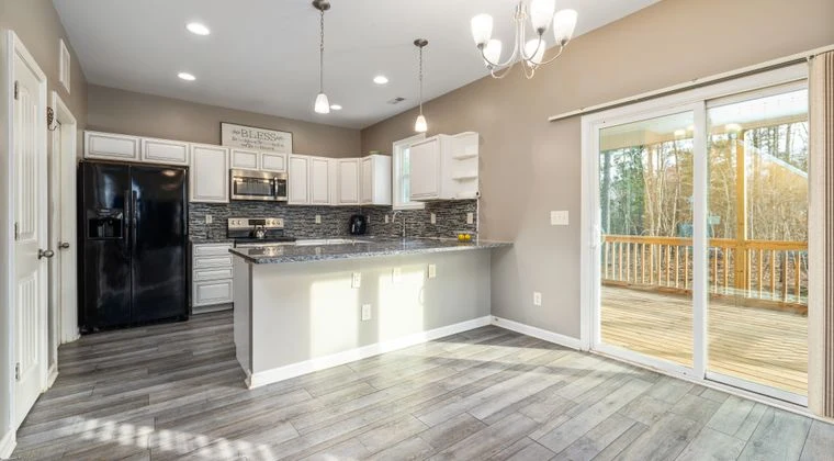 Spacious modern kitchen with island and sliding doors to a balcony, ideal for culinary enthusiasts