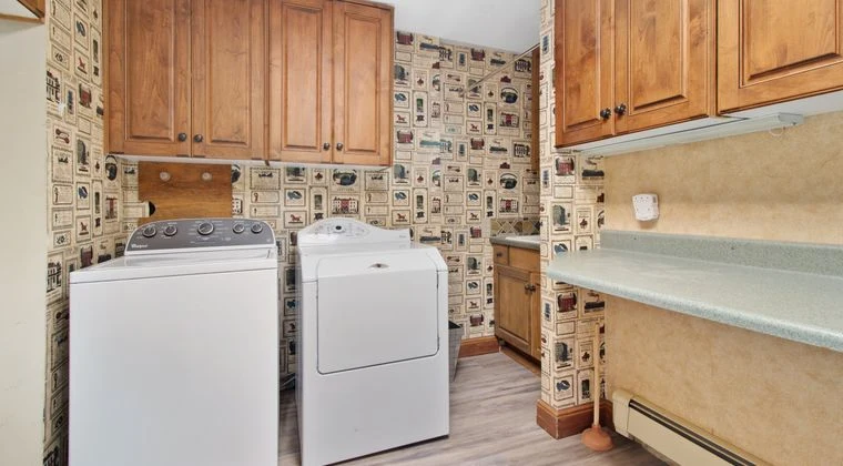 Cozy laundry room with wooden cabinets, washer, and dryer setup