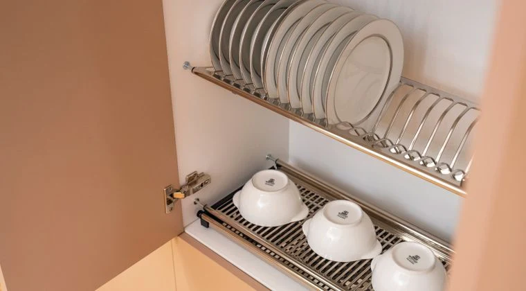 A clean and organized kitchen cabinet displaying plates and bowls on a drying rack