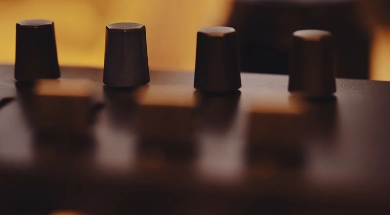 Artistic close-up of modern equipment knobs with warm light and soft focus for a cinematic feel