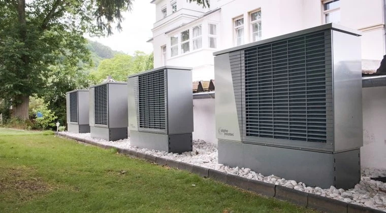 Row of heat pumps outside a building promoting sustainable energy solutions