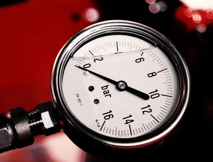 Detailed view of a bar pressure gauge used in industrial settings, emphasizing precision and measurement